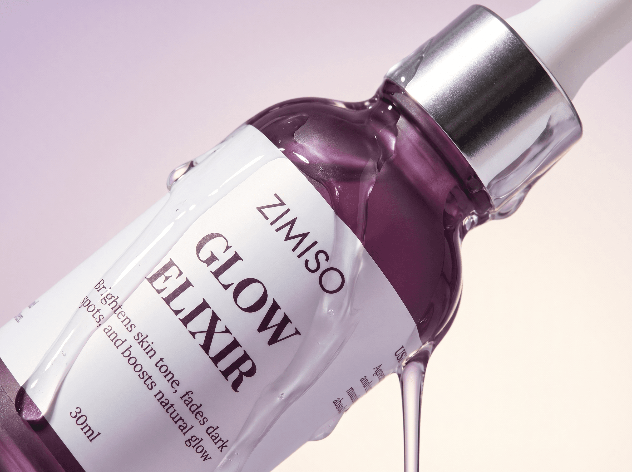 Macro close-up of the ZIMISO Glow Elixir bottle with serum running down the glass