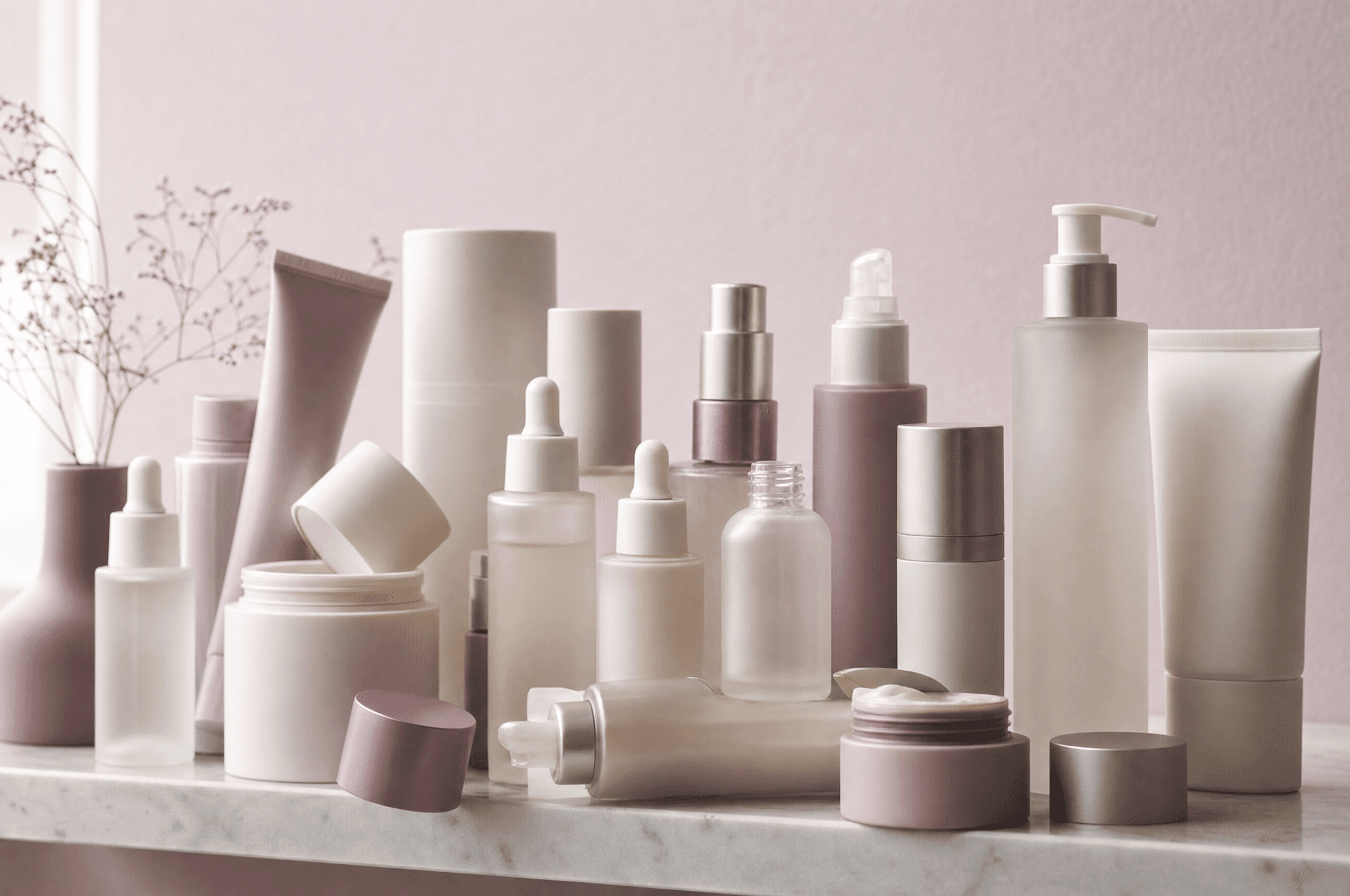 A bathroom shelf overcrowded with more than a dozen skincare products